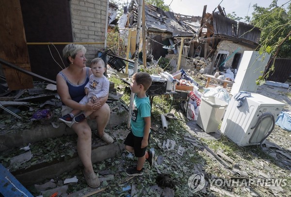 러시아 침공 뒤 폐허가 된 집 앞에 있는 우크라 어린이들 / 사진출처=연합뉴스